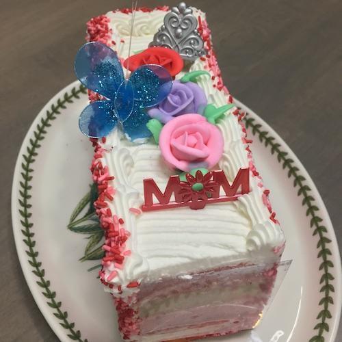 Orland Park Bakery Mother's Day Dobish Torte are 5 layers of white cake filled with butter cream and strawberry preserves, iced with butter cream, and finished with pastel sprinkles on the sides.